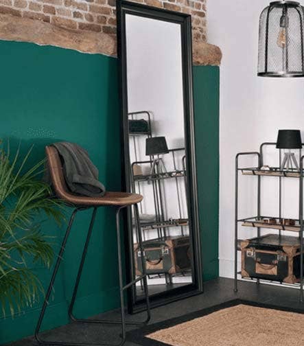 Espejo de cuerpo entero con marco negro en un espacio de decoración moderna.