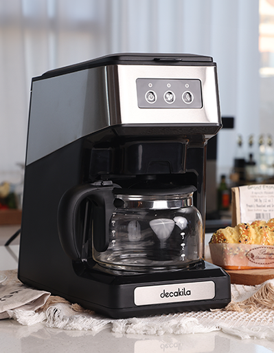 Cafetera eléctrica negra con jarra de vidrio en una encimera de cocina.