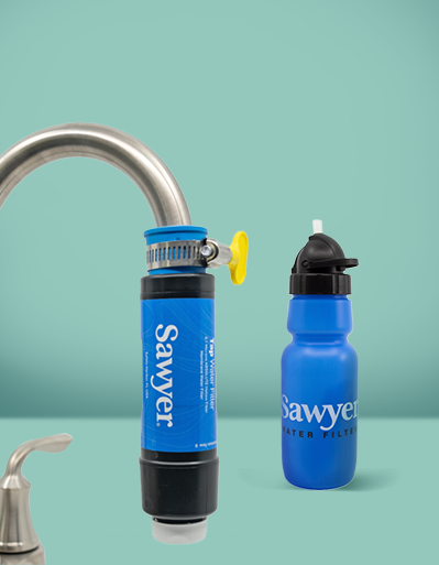 Sistema de filtración de agua conectado a un grifo, junto a una botella reutilizable azul, para proporcionar agua potable purificada al instante
