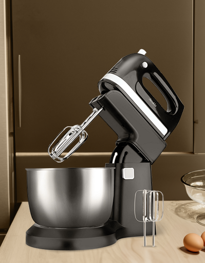 Batidora de mano negra con tazón metálico en una cocina moderna.