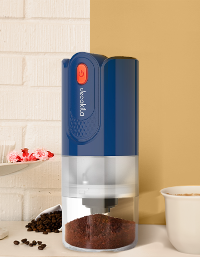 Molino de café eléctrico azul y blanco con taza y frascos de café en fondo amarillo.