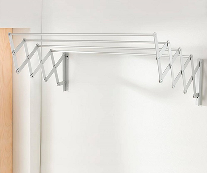Tendedero de aluminio plegable para optimizar espacio. Tendedero de aluminio plegable montado en pared, sobre fondo blanco.